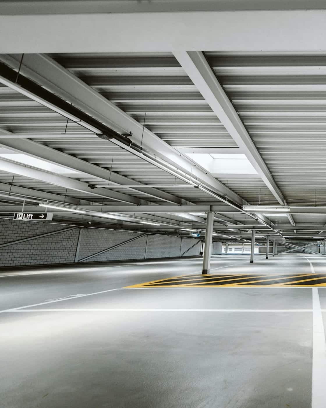 An empty multi-storey parking deck with marked bays and lane guidance
